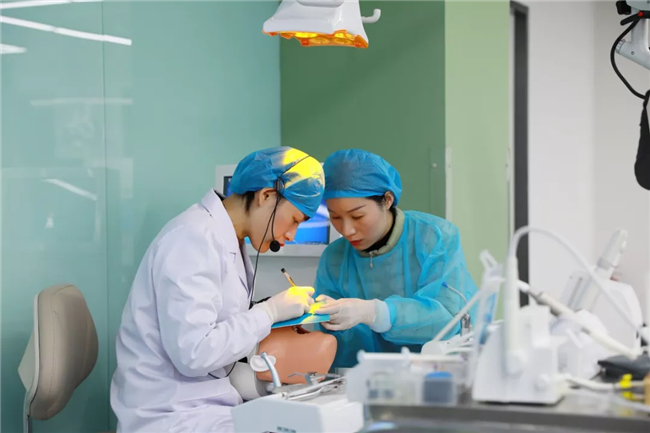 陈菲菲、杨亚丽医师演示橡皮障隔离技术。